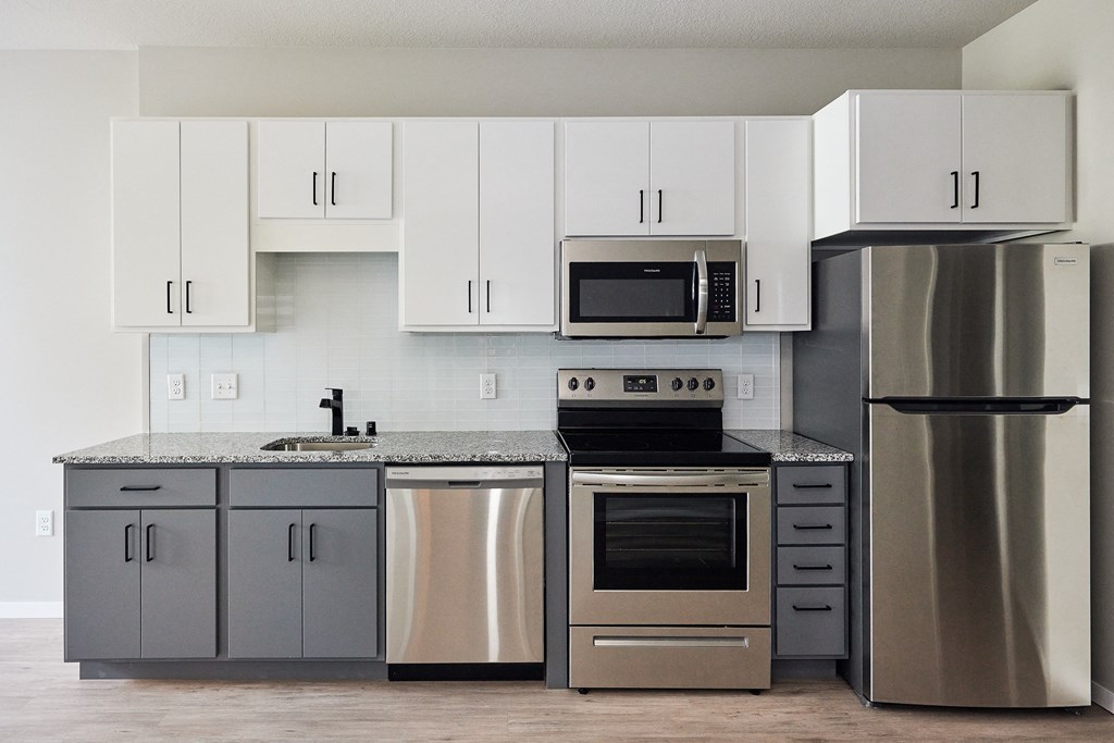 a kitchen with stainless steel appliances and white cabinets