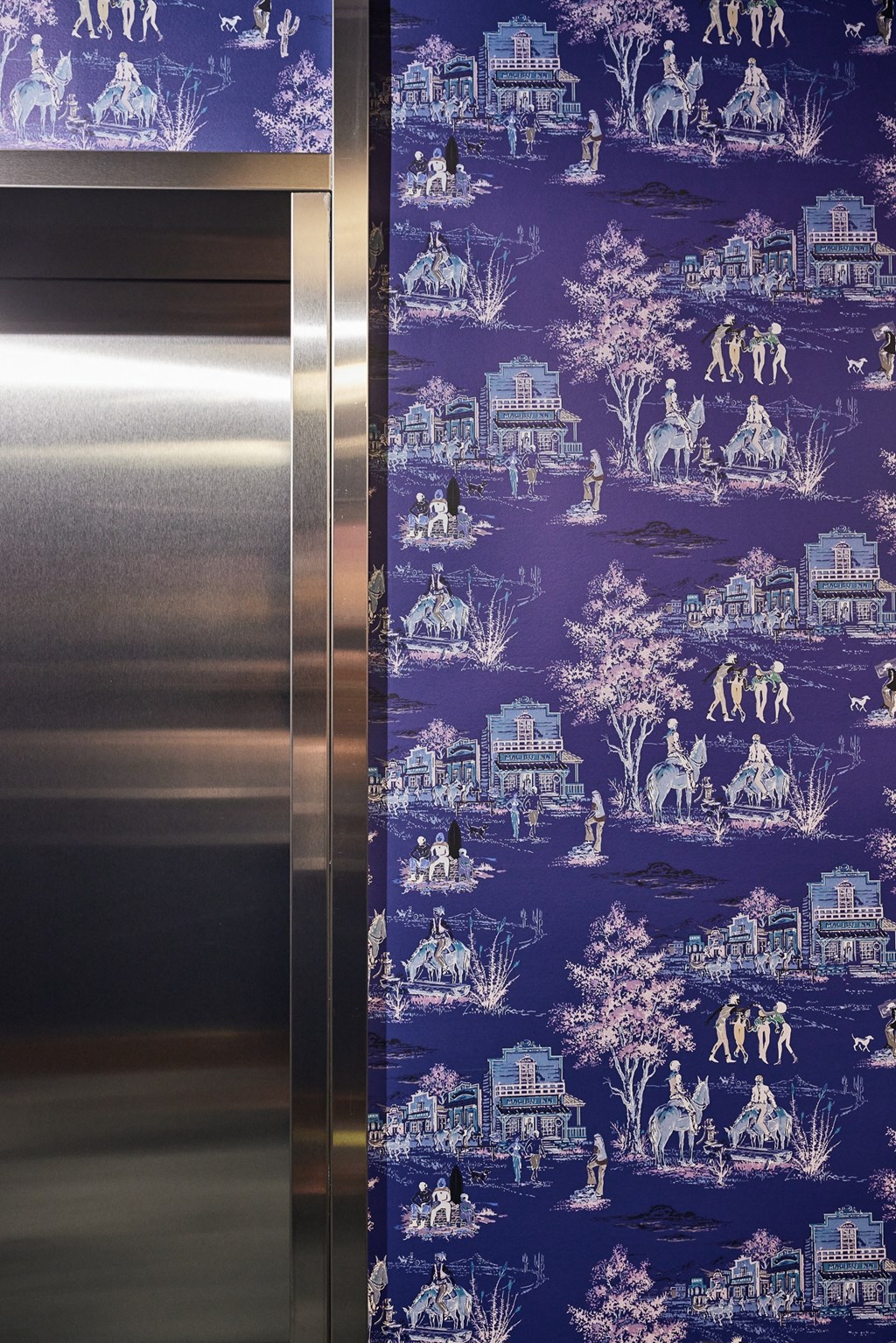 a close up of a metal elevator with a blue wallpaper