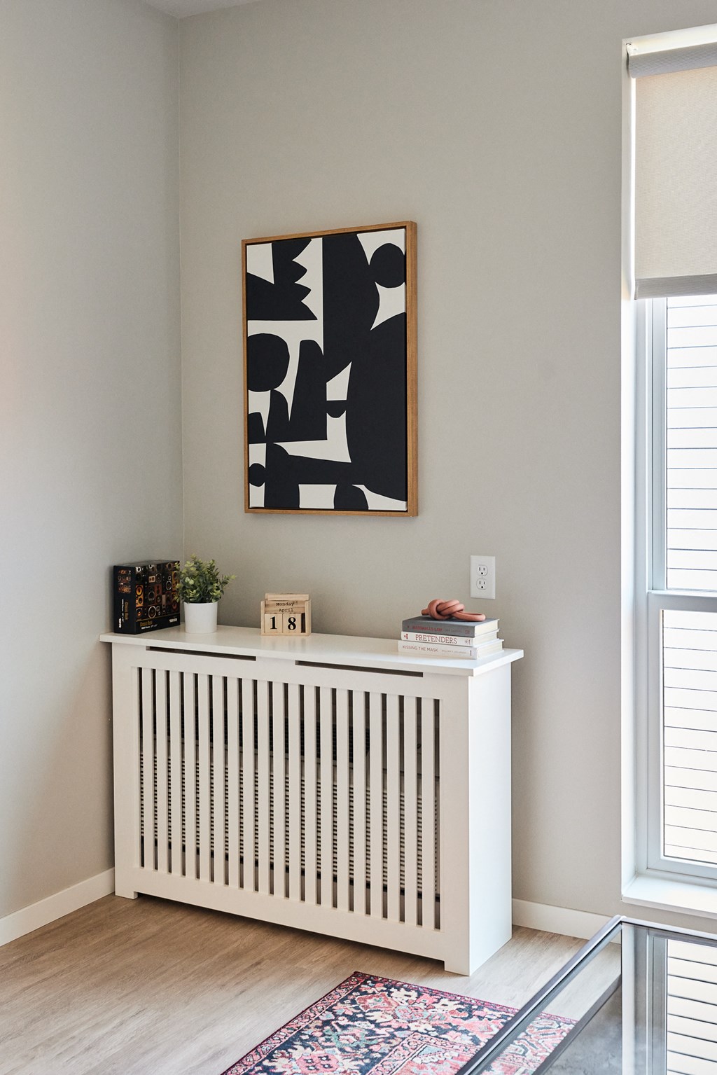 a room with a radiator and a painting on the wall