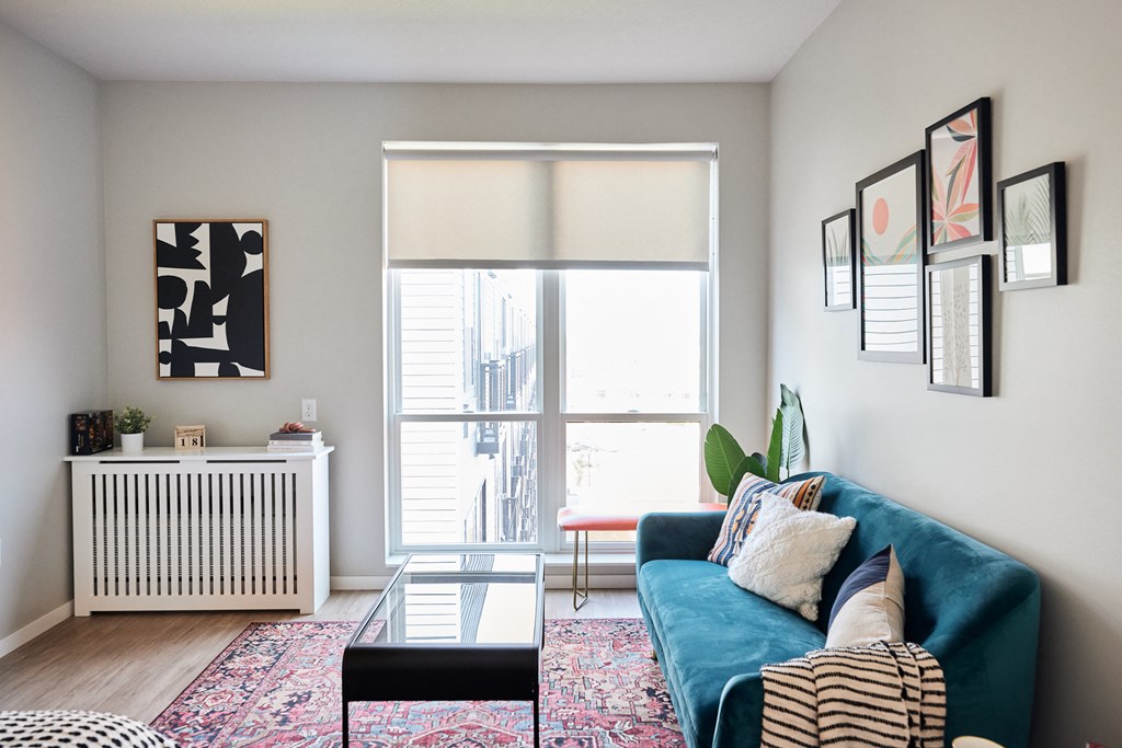 a living room with a blue couch and a window