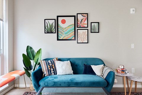 a living room with a blue couch and pictures on the wall