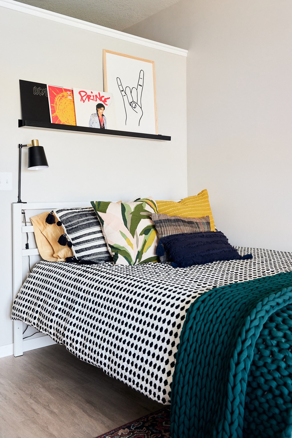 a bedroom with a bed with black and white checked pillows and a blue blanket