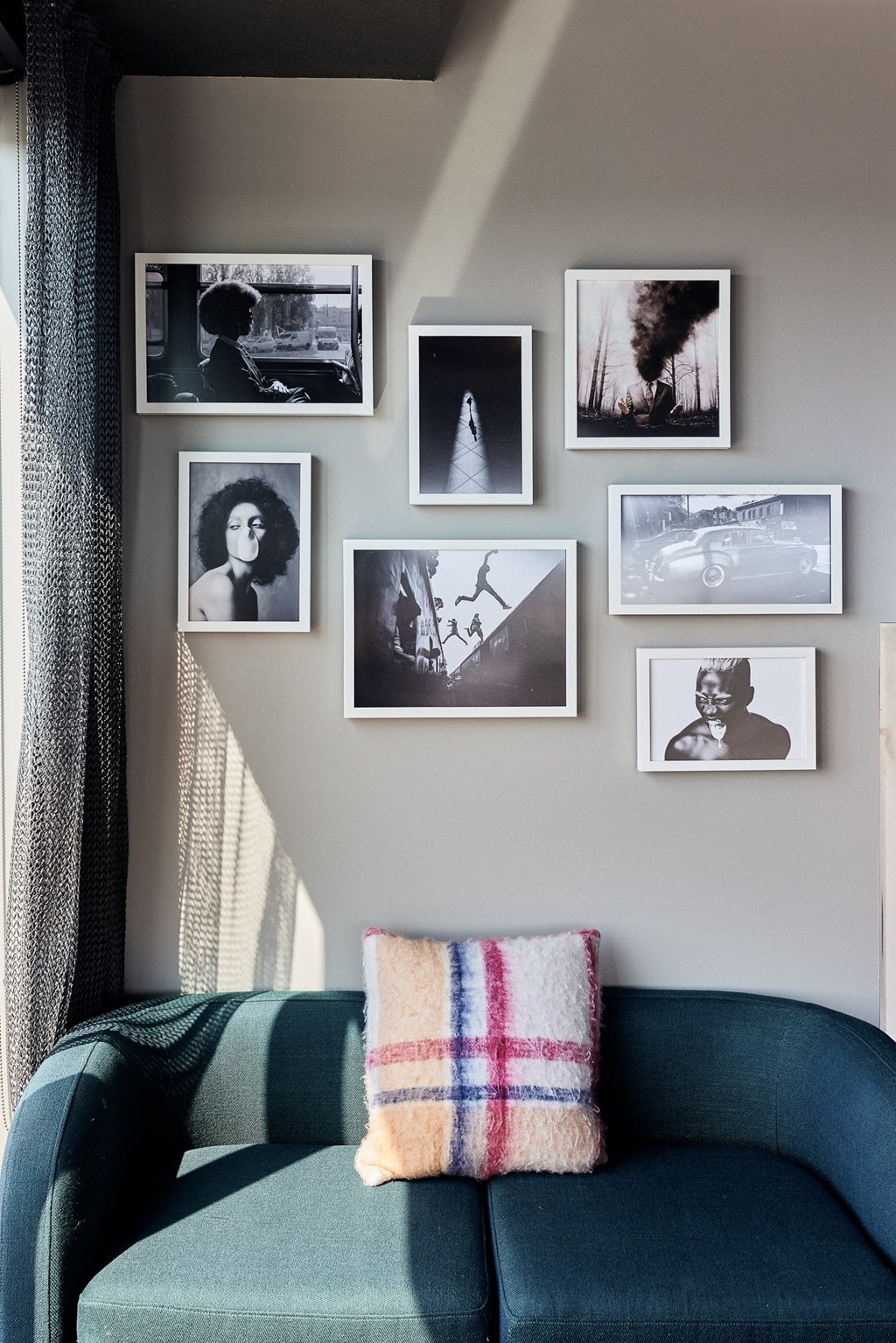 a living room with a green couch and pictures on the wall