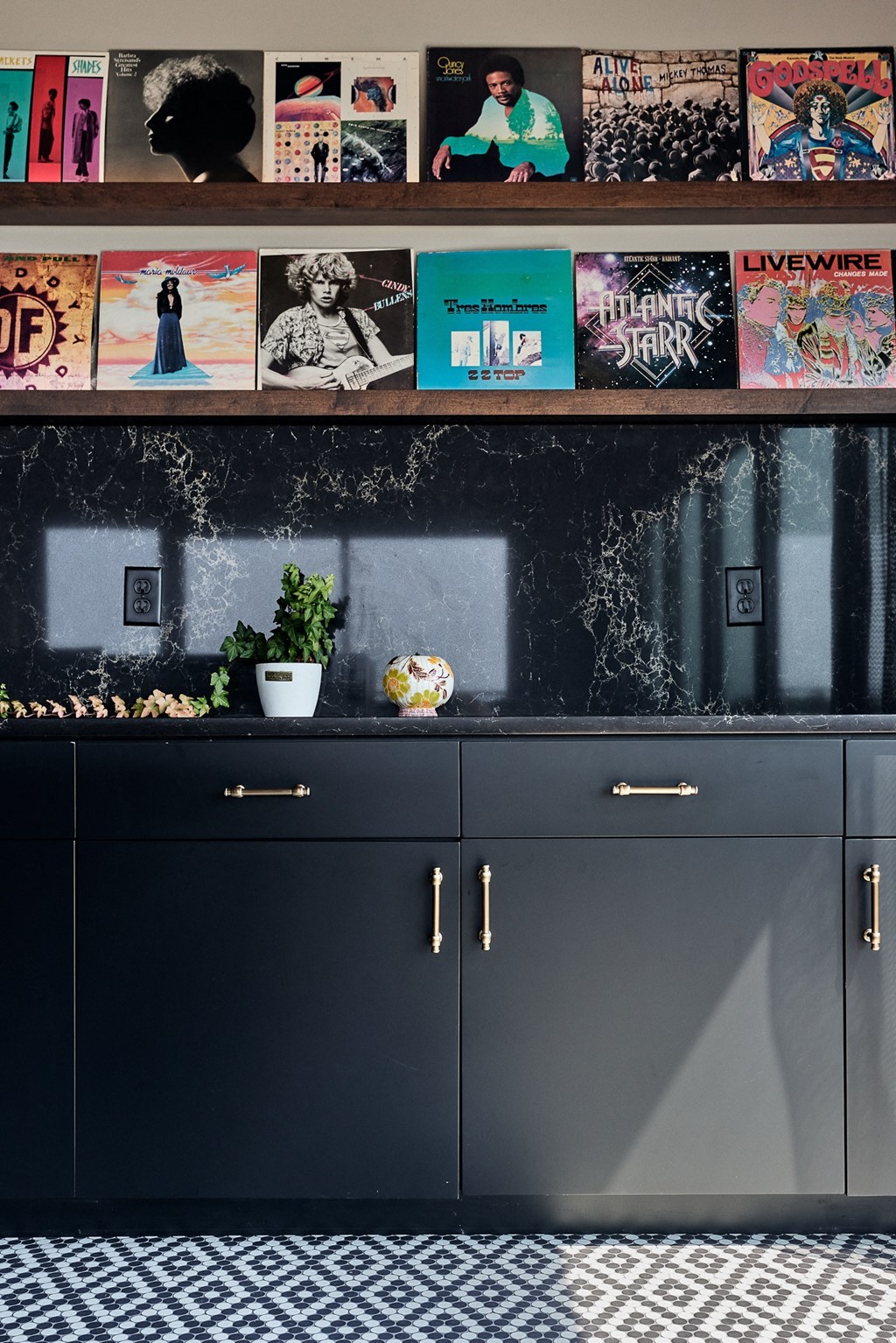 a kitchen with black cabinets and a black and white checkered floor