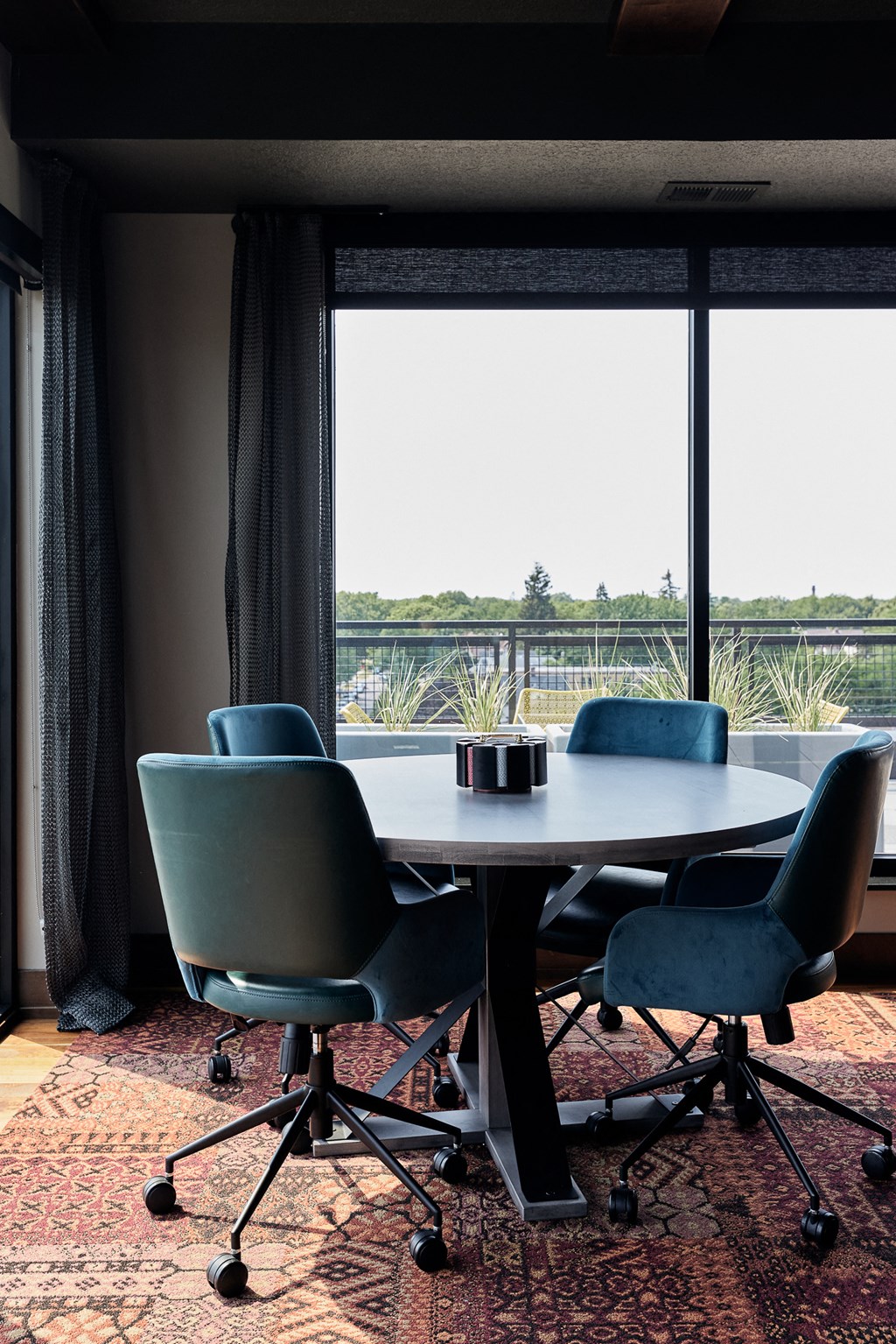 a round table with chairs in front of a window