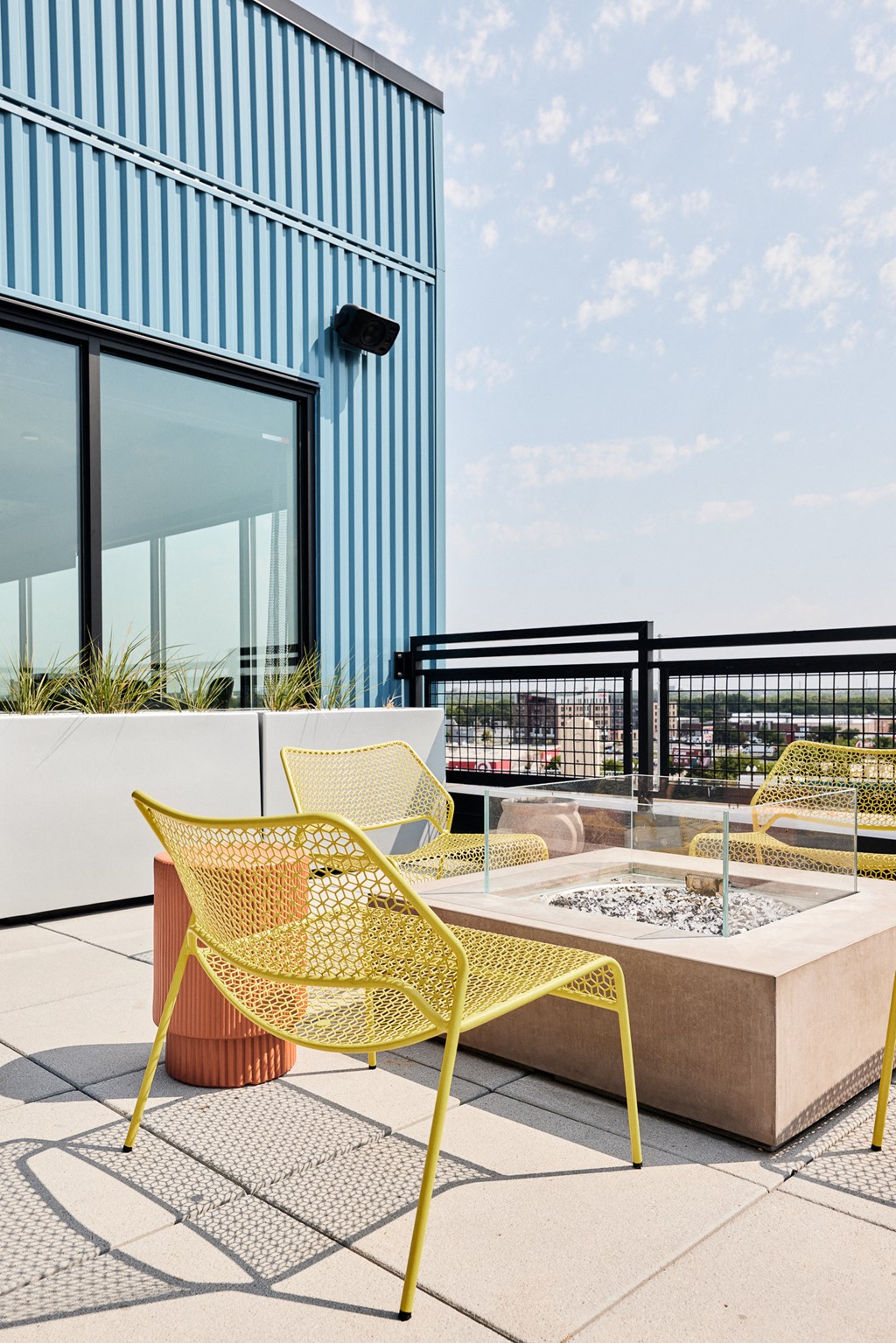 a seating area with yellow chairs and a table on a balcony
