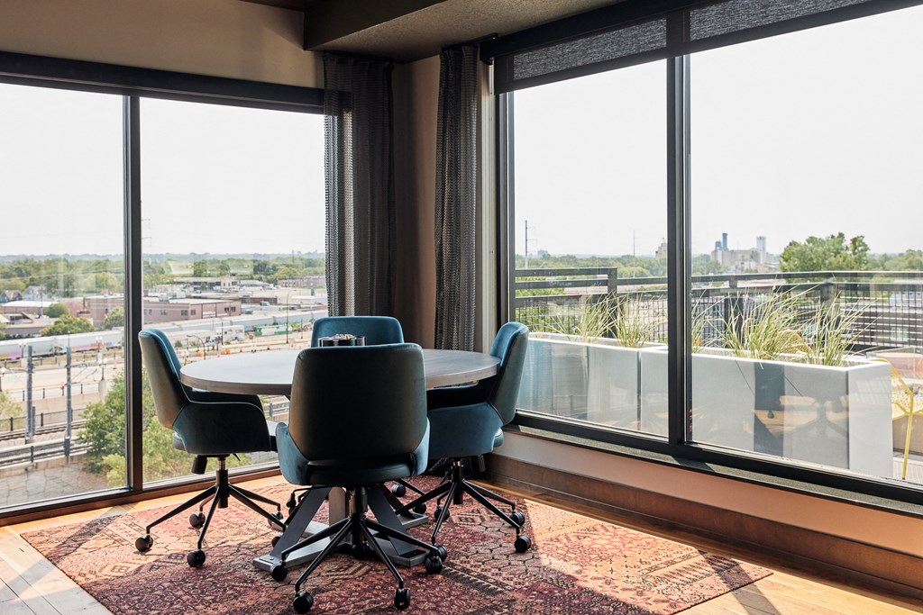 a conference room with a table and chairs in front of a window
