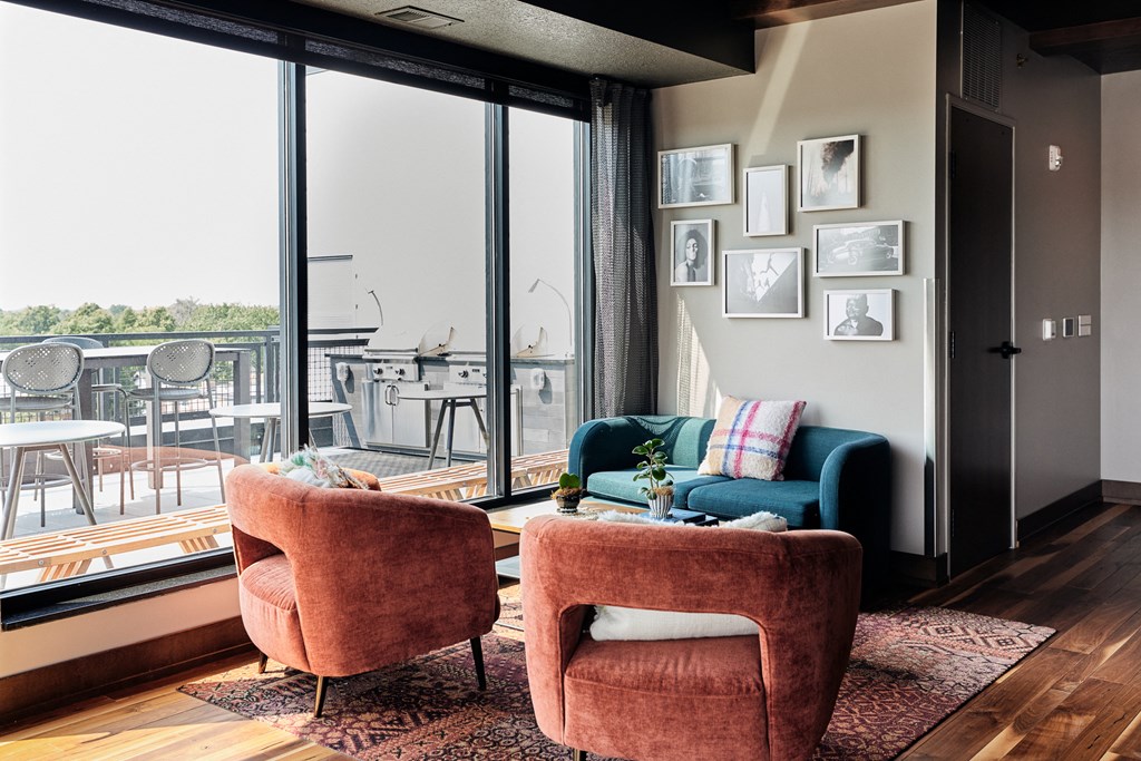 a living room with two chairs and a couch and a balcony