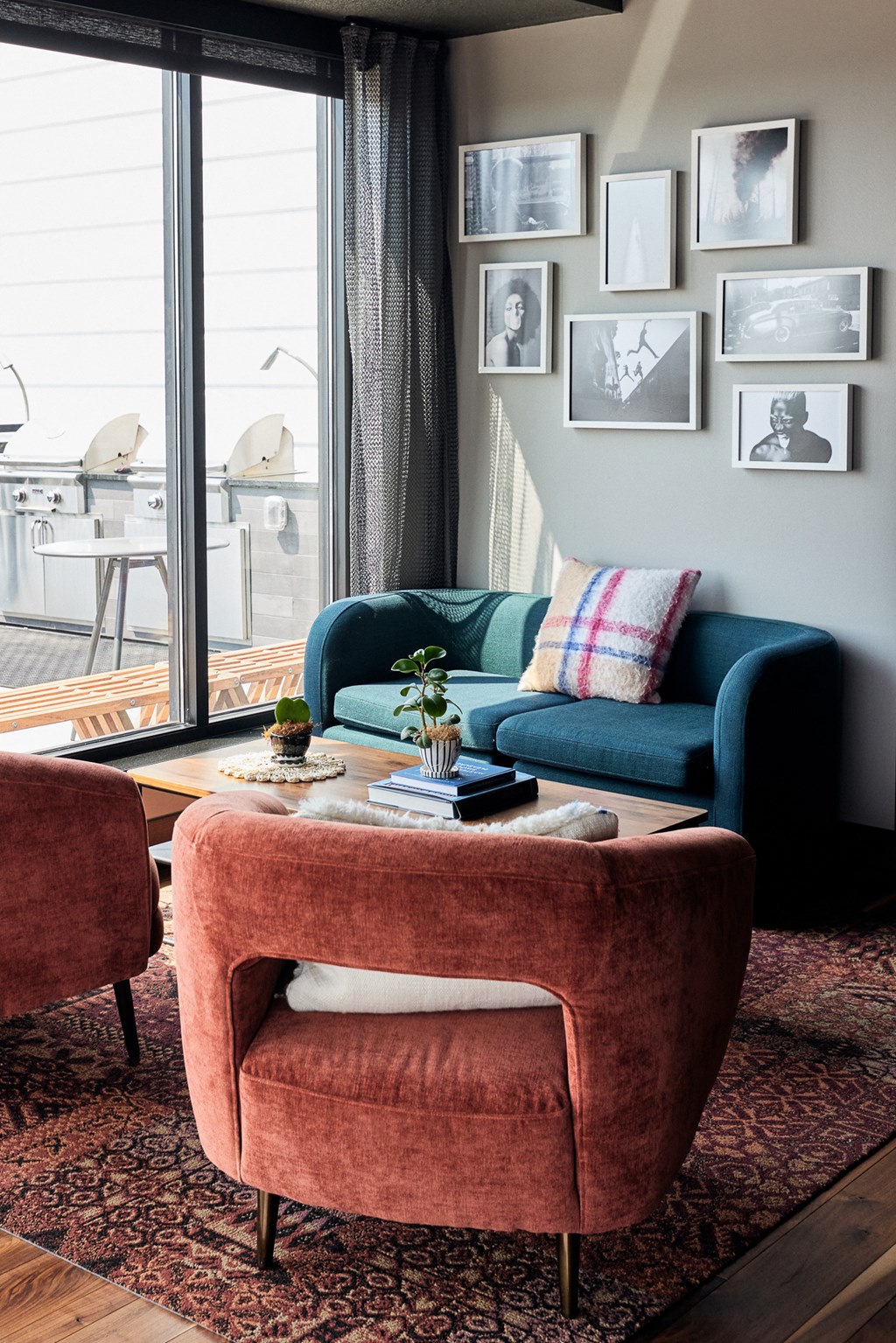 a living room with a blue couch and a red chair and a coffee table