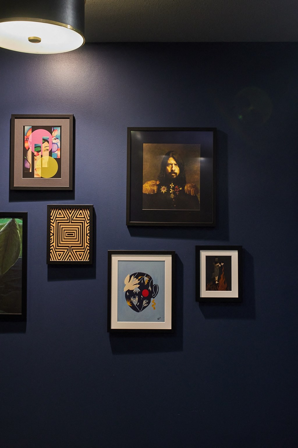 a wall of framed pictures on a black wall