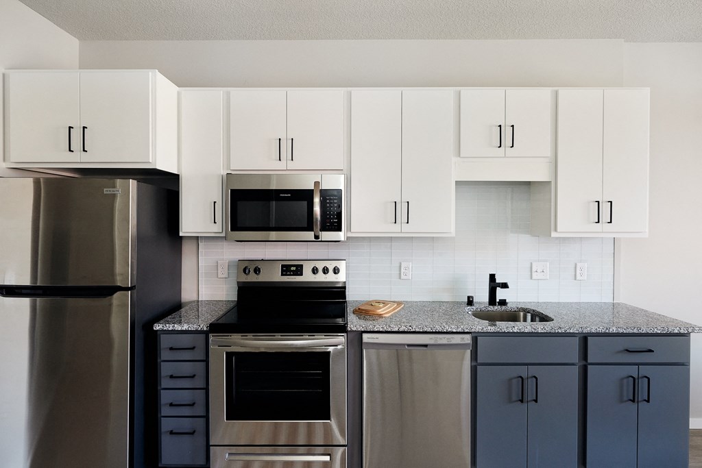 a kitchen with stainless steel appliances and white cabinets