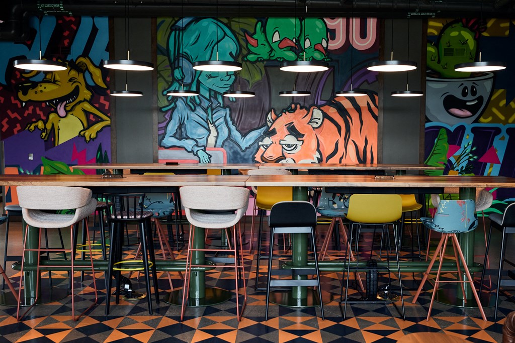 a communal table in a restaurant with graffiti on the wall