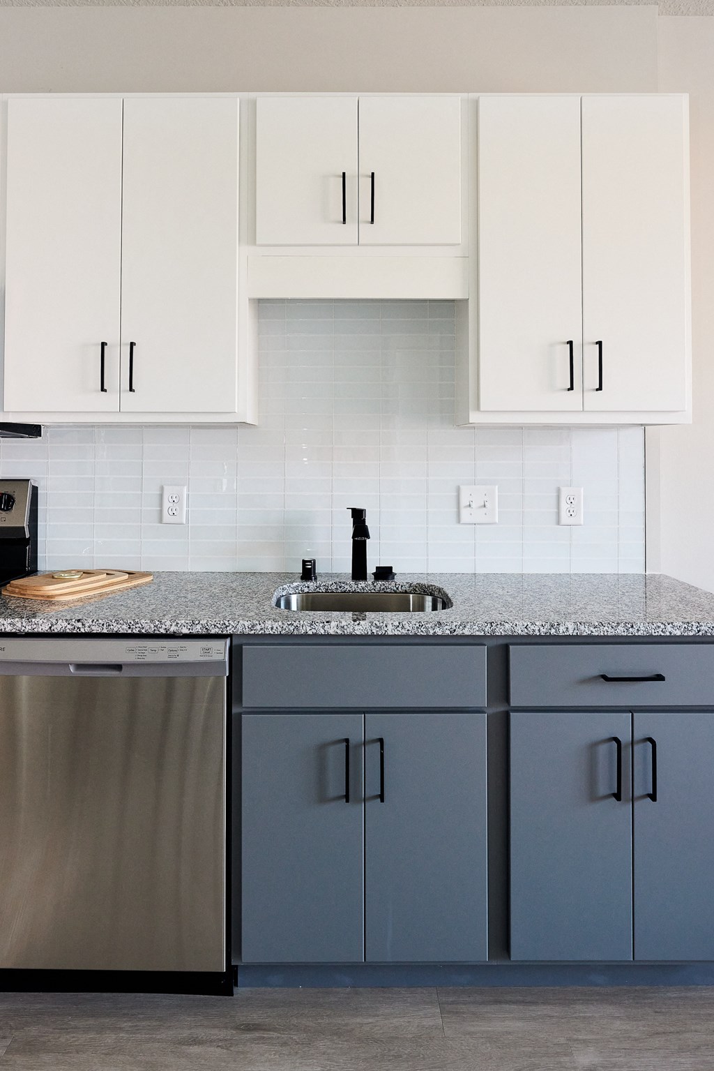 a kitchen with blue and white cabinets and a sink
