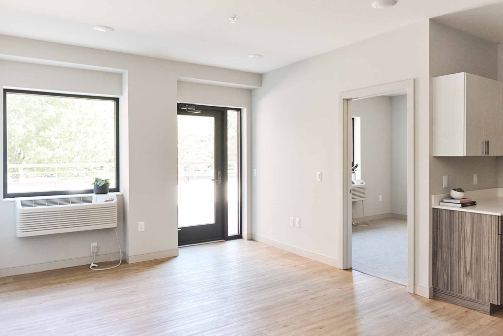 an empty living room with a wooden floor and a window