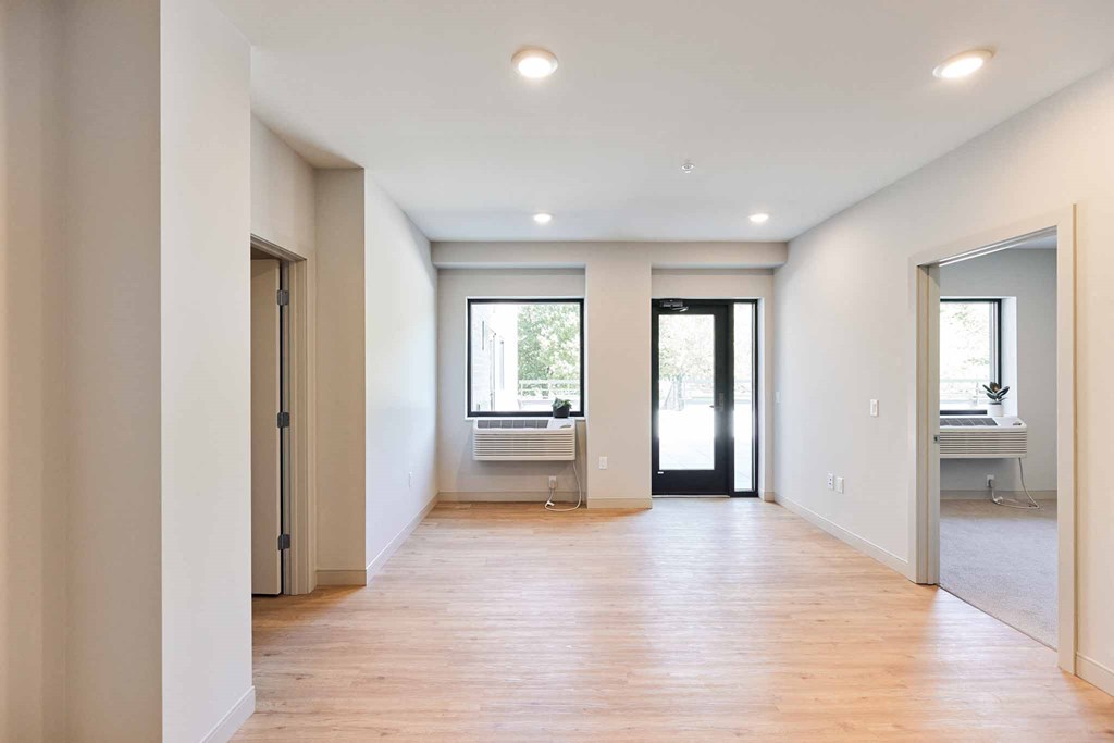 a living room with a hard wood floor and white walls