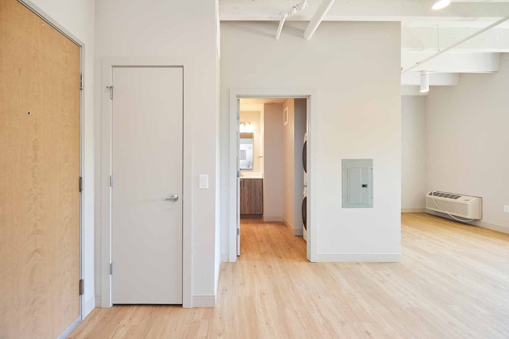 a renovated living room and hallway with wood floors and white walls
