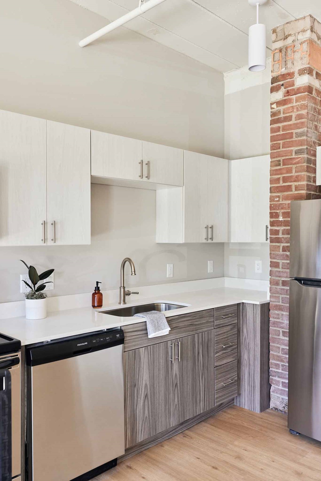 a kitchen with white cabinets and a sink and a refrigerator