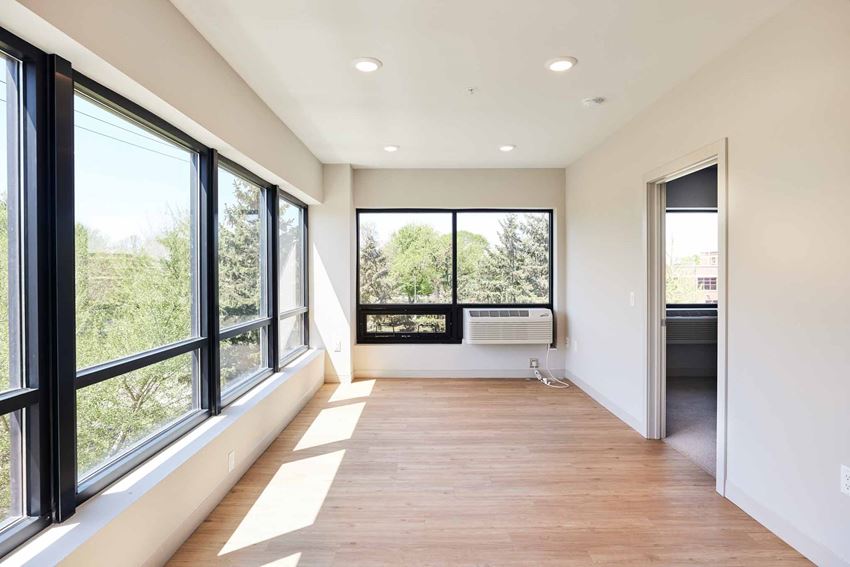 a living room with large windows and a wood floor