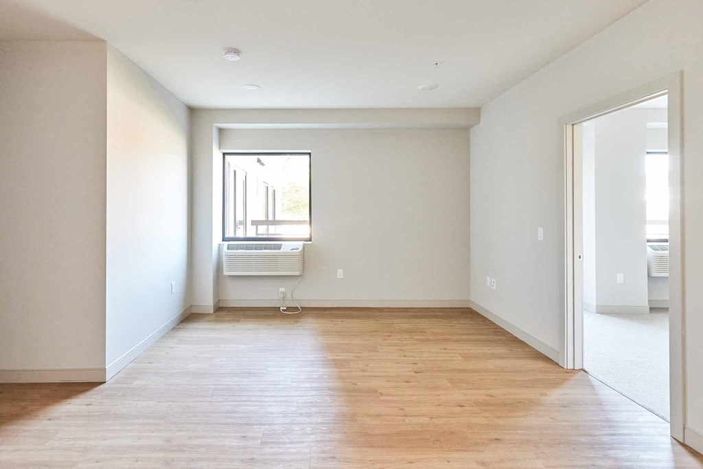 an empty living room with white walls and a window