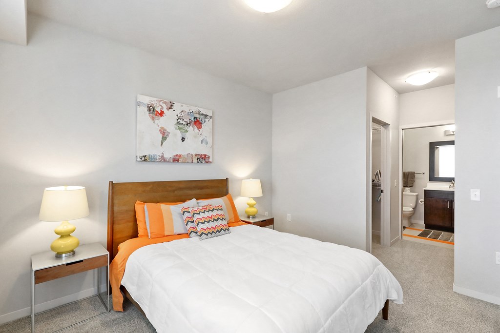 a bedroom with a white bed and a painting on the wall