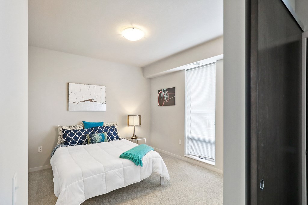 a bedroom with a bed and a large window