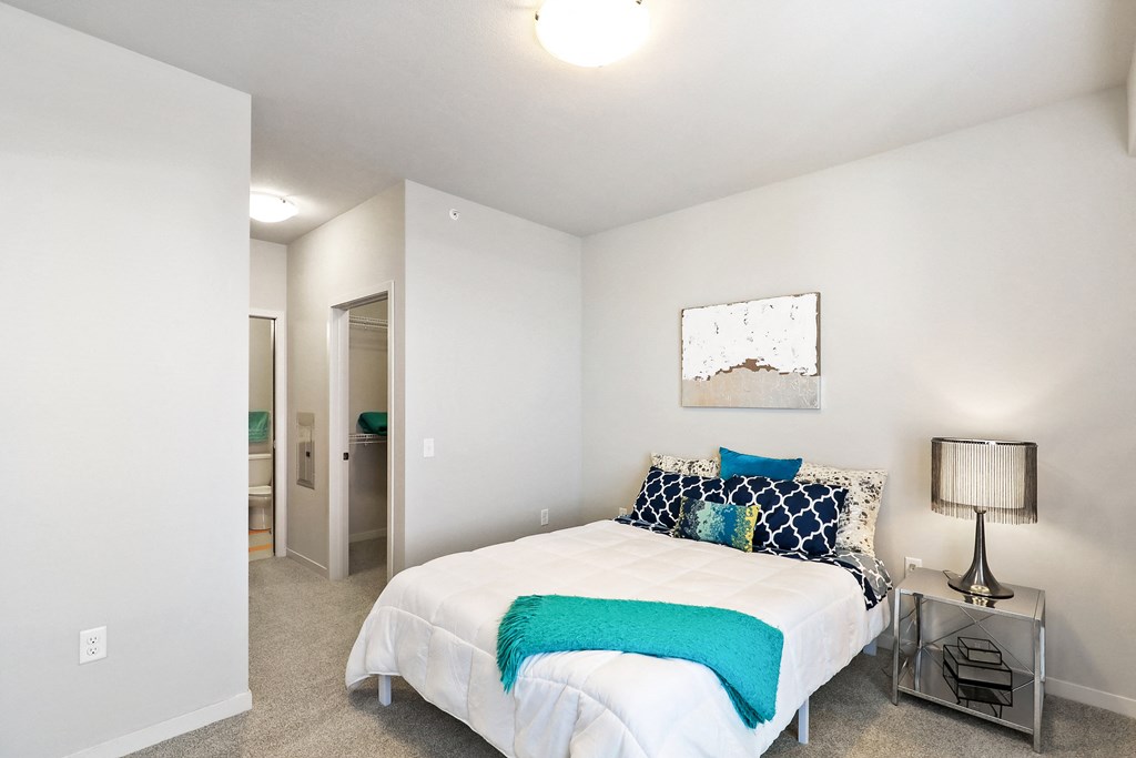 a bedroom with a white bed and a blue blanket
