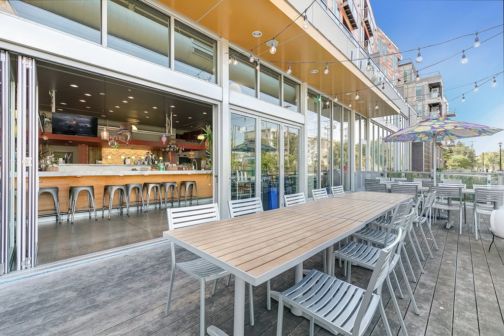 a long communal table and chairs outside of a restaurant