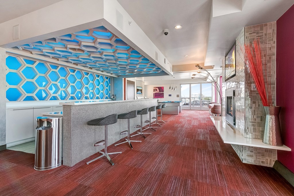 a long bar with stools in a room with a fireplace