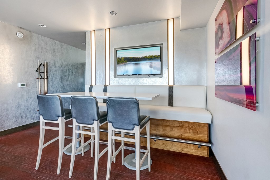 a kitchen with a bar and stools and a painting on the wall