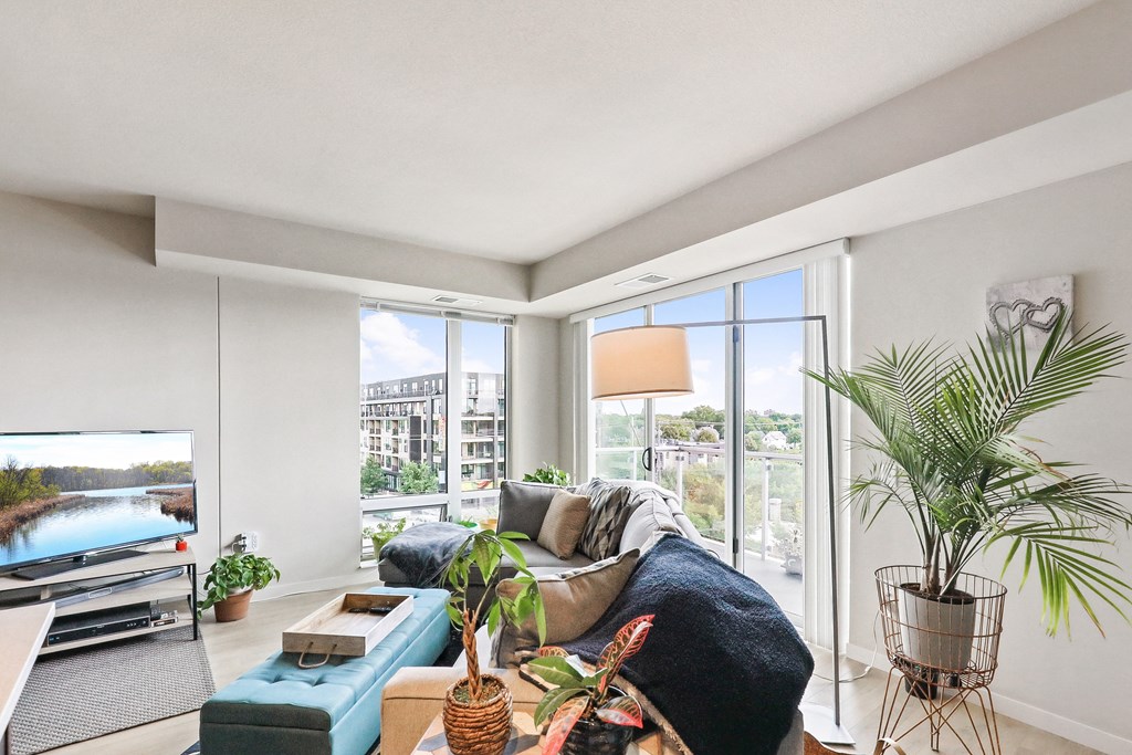 a living room with a couch and a large window with a view of a river