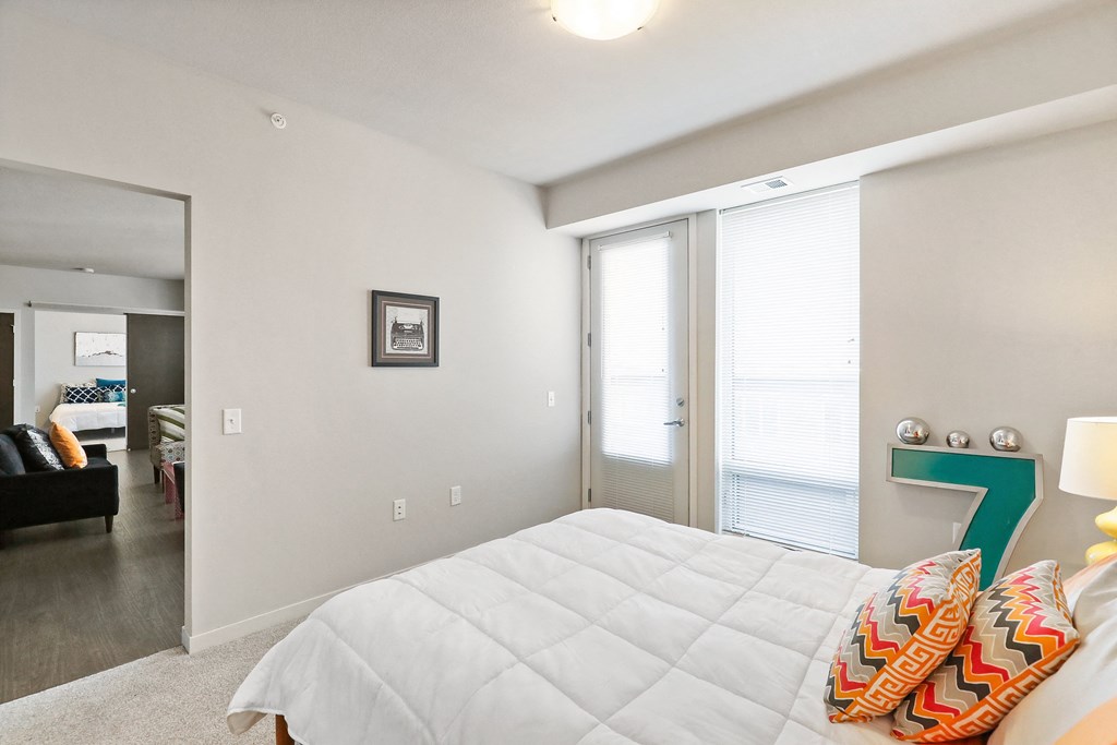 a bedroom with a large white bed and a large window