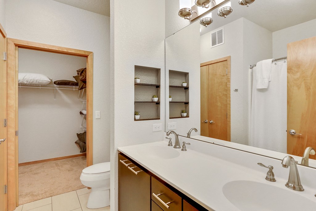 a bathroom with a large mirror and a sink and a toilet