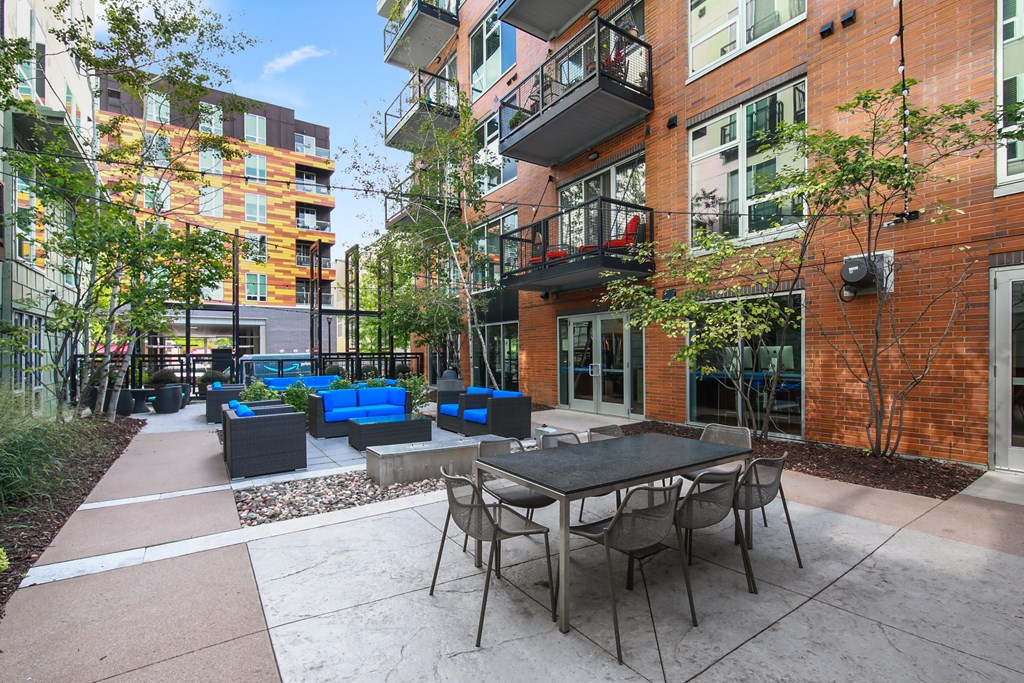an outdoor patio with tables and chairs in front of a building