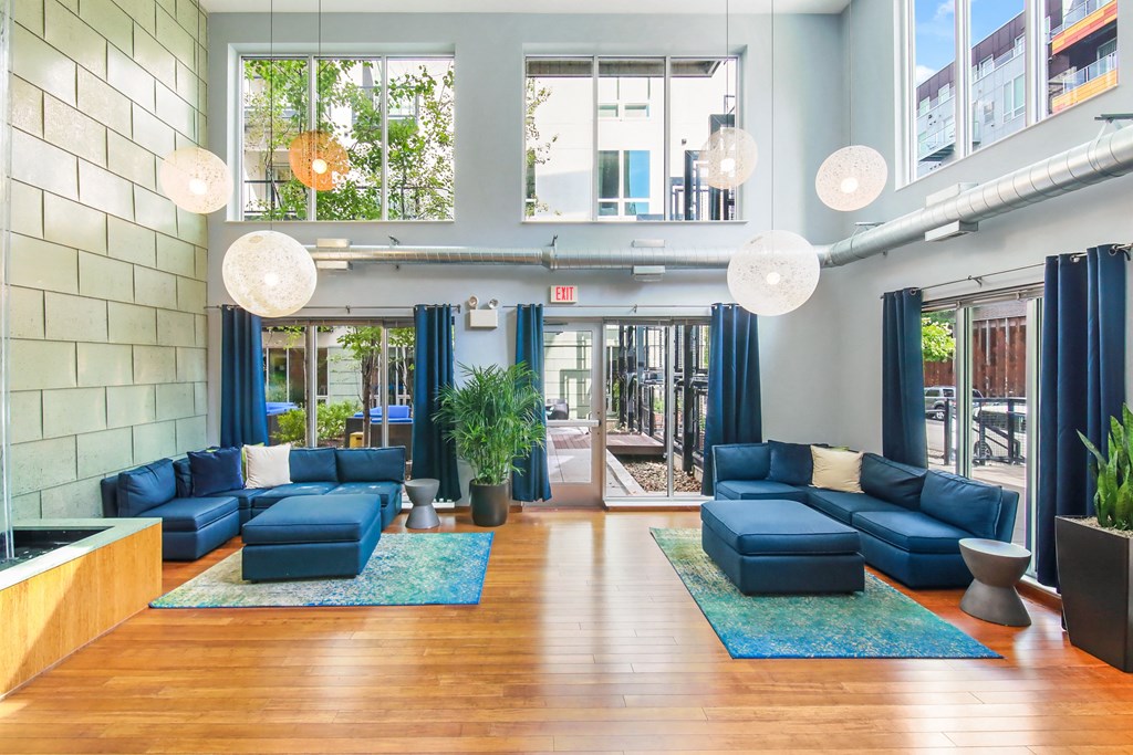 the lobby of a building with blue couches and blue rugs