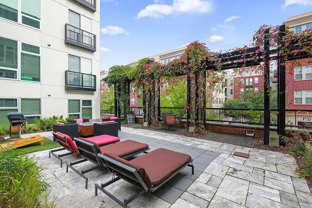 an outdoor patio with lounge chairs and a pergola