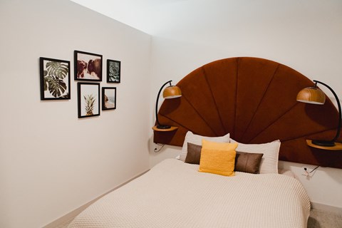 a bedroom with a bed and a wooden headboard
