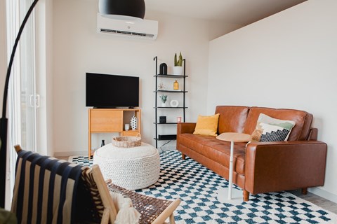 a living room with a leather couch and a tv