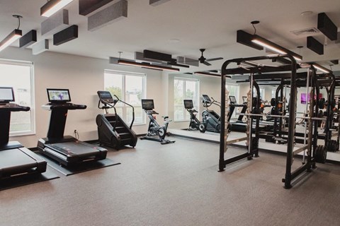a gym with exercise equipment and windows in a building