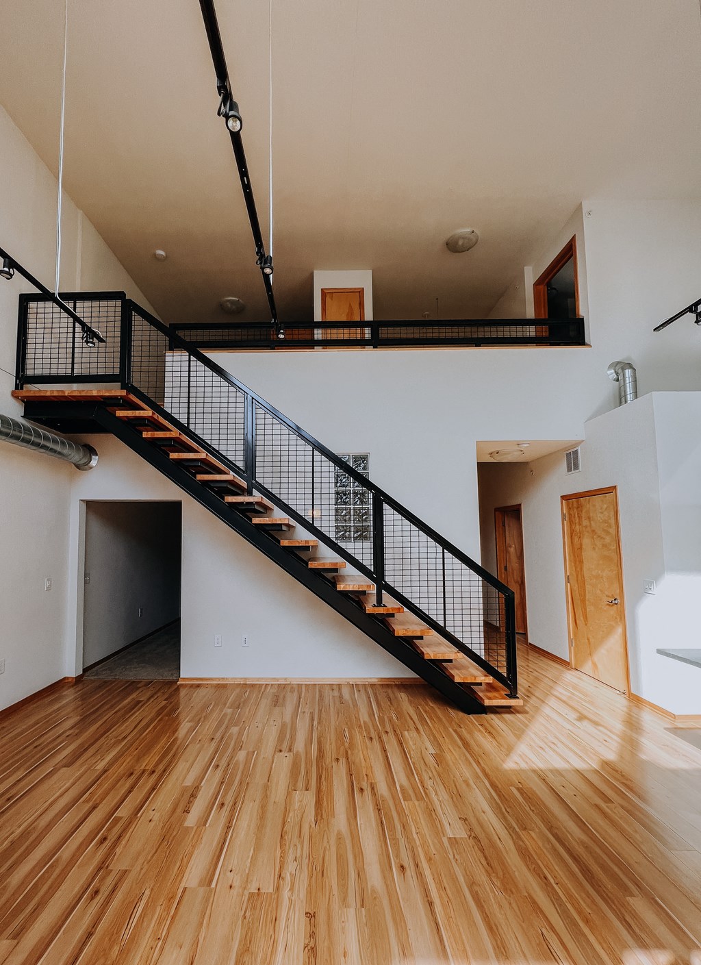 a stairwell in a house with wood floors and a railing on top of it