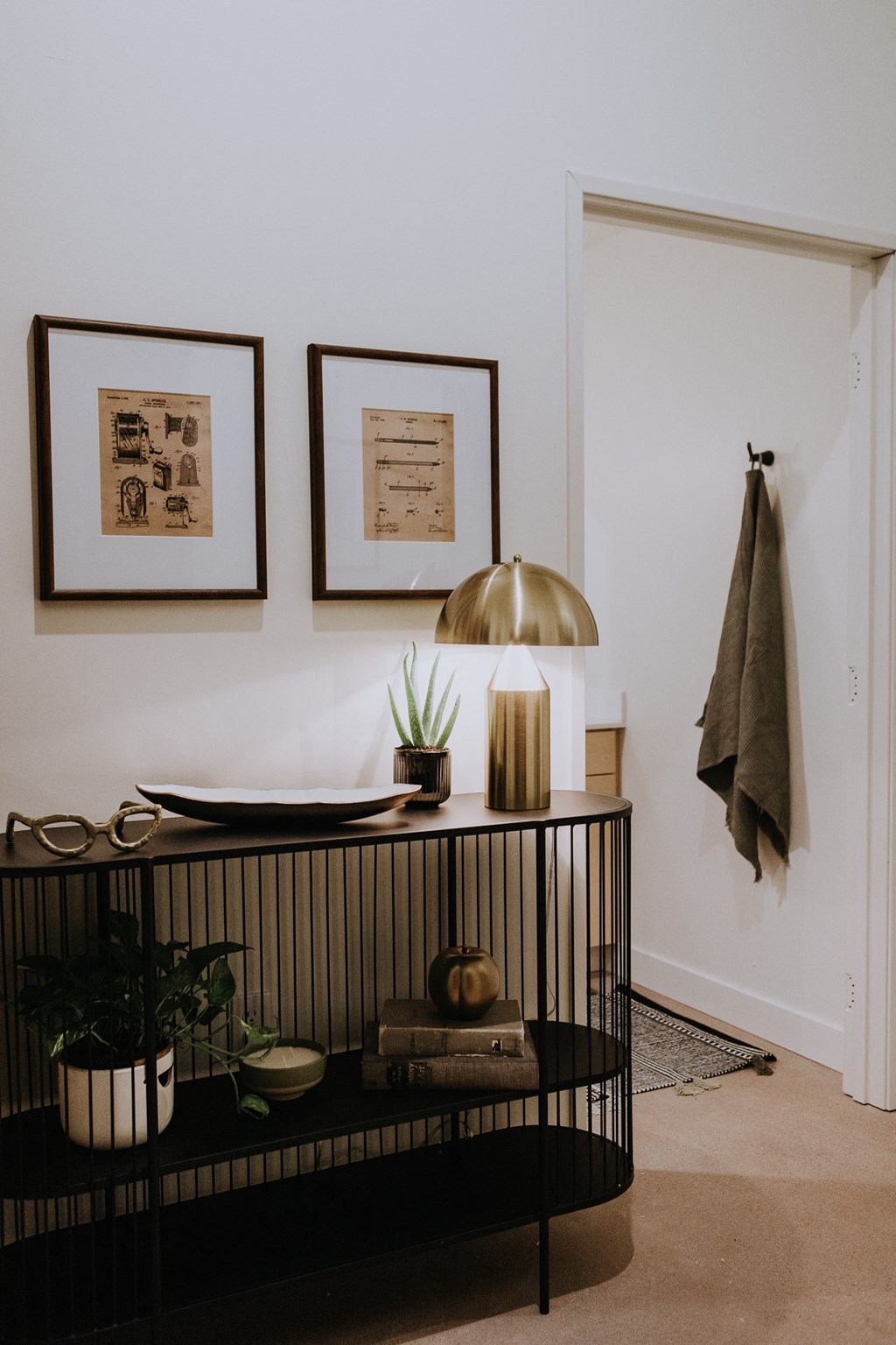 a living room with a shelf and pictures on the wall