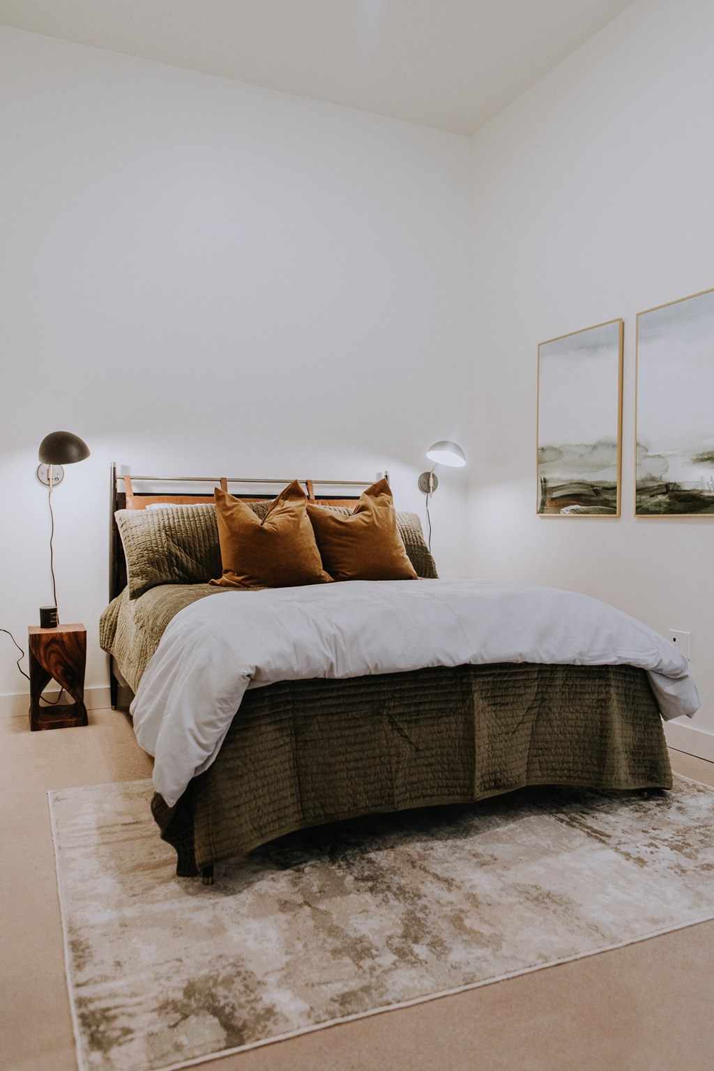 a bedroom with a bed and two lamps and a rug