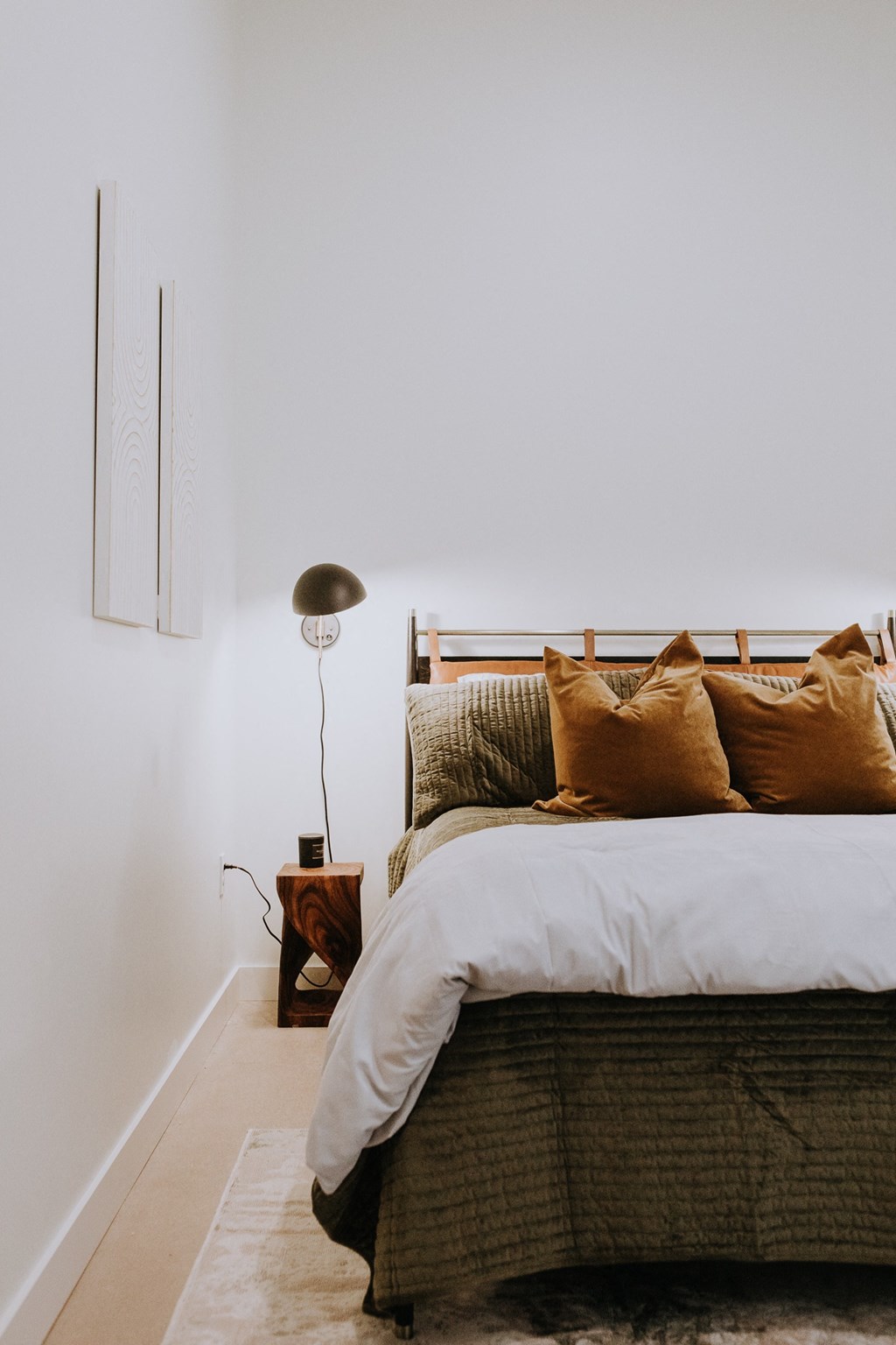 a bedroom with a bed with pillows and a lamp