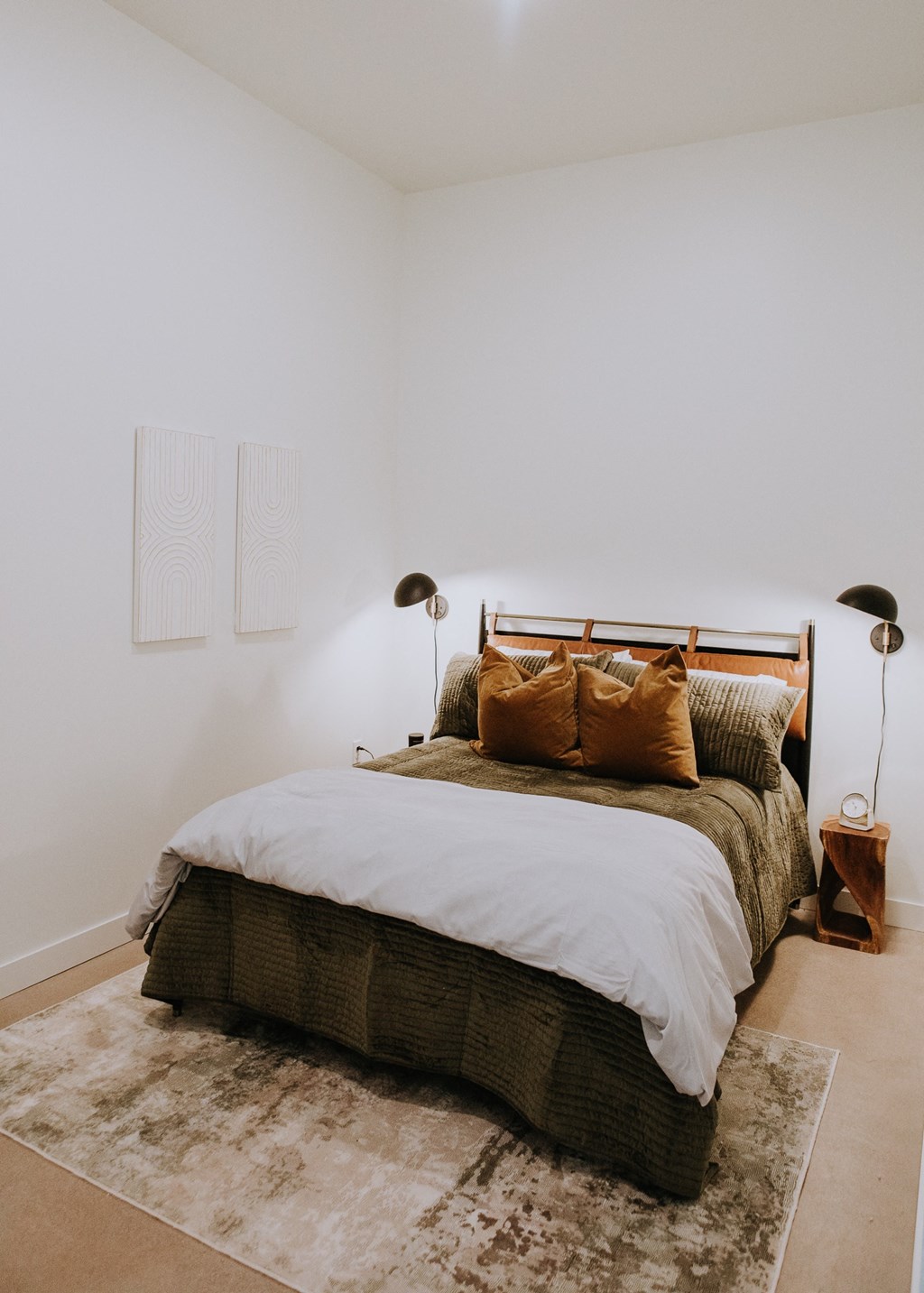 a bedroom with a bed and two lamps and a rug