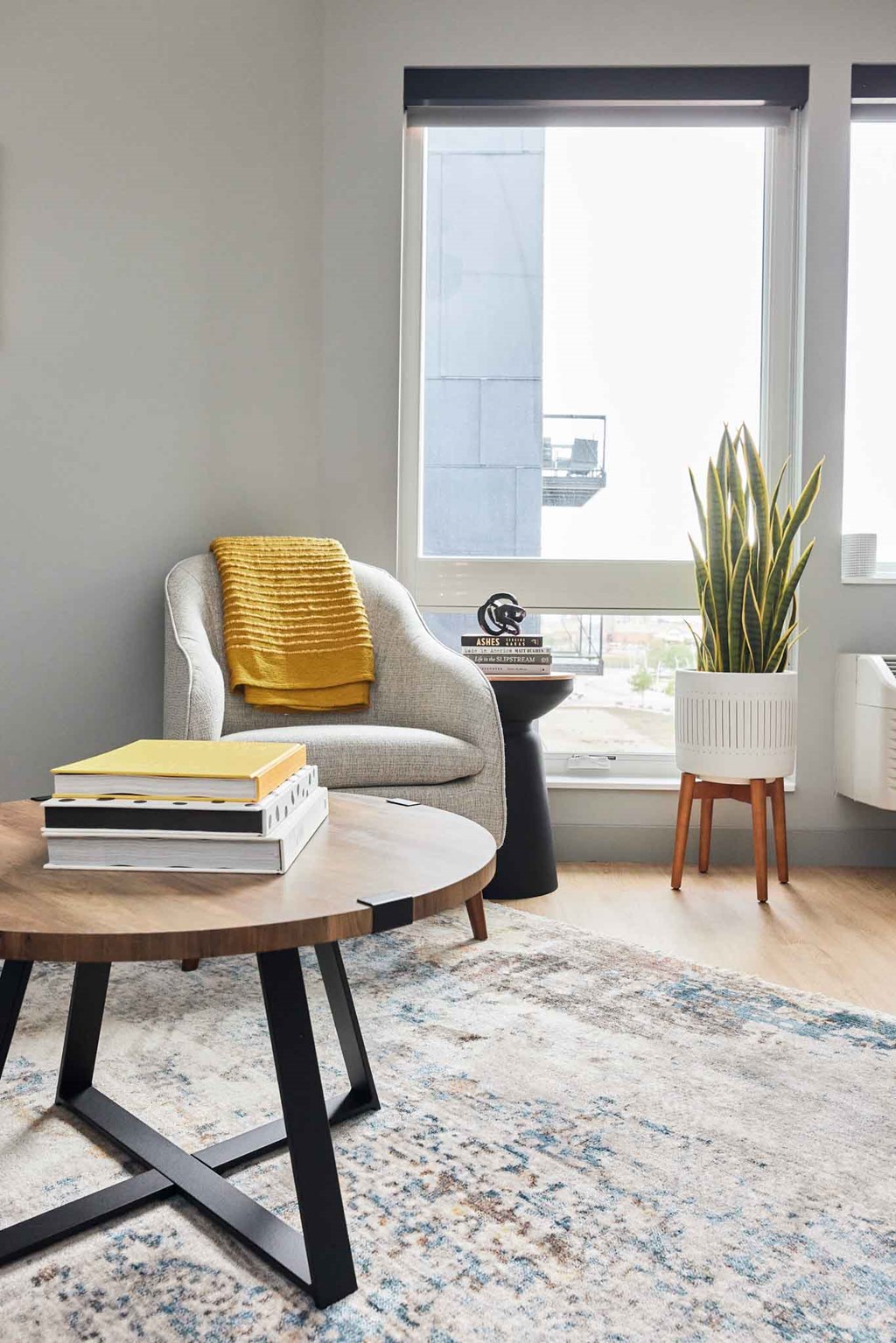 a living room with a chair and a table and a window