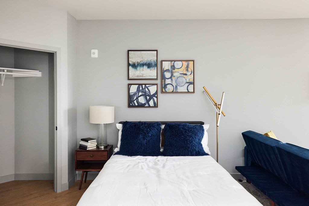 a bedroom with a bed and paintings on the wall