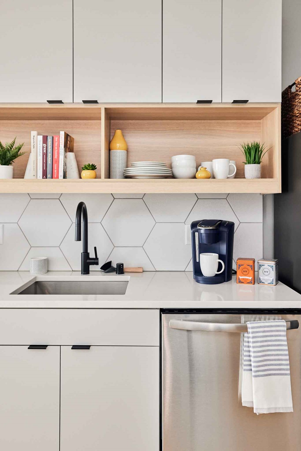 a kitchen with white cabinets and a sink and a coffee maker