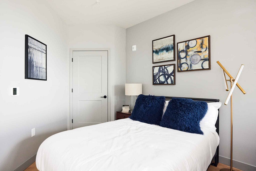 a bedroom with a white bed and pictures on the wall