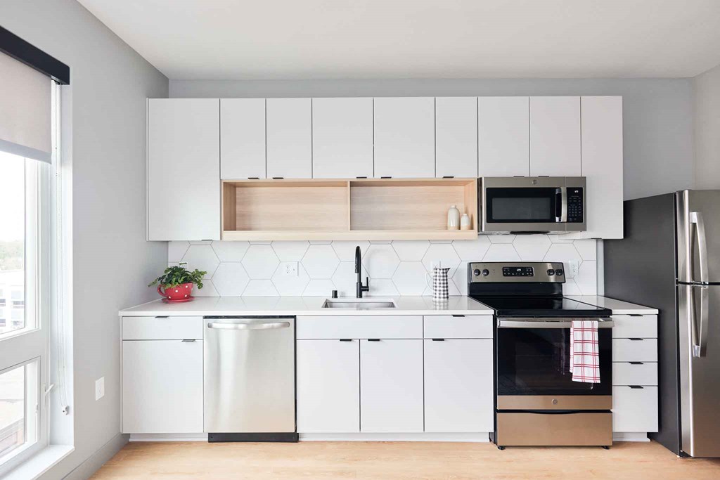 a kitchen with white cabinets and a stove and a refrigerator