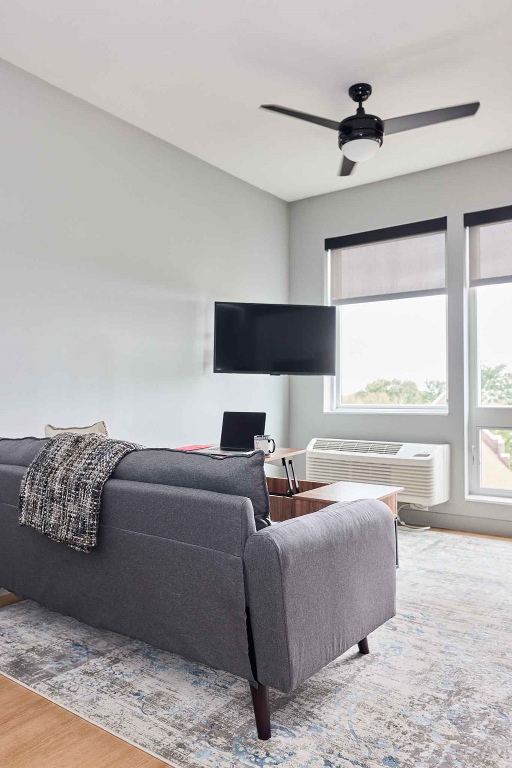 a living room with a couch and a ceiling fan