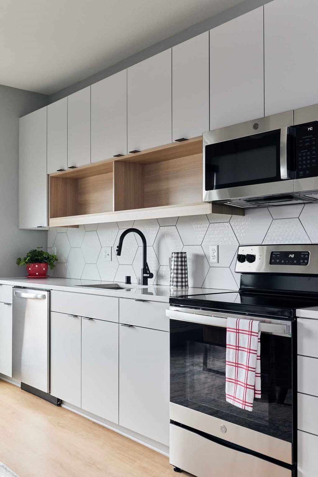 a kitchen with white cabinets and a stove and a microwave